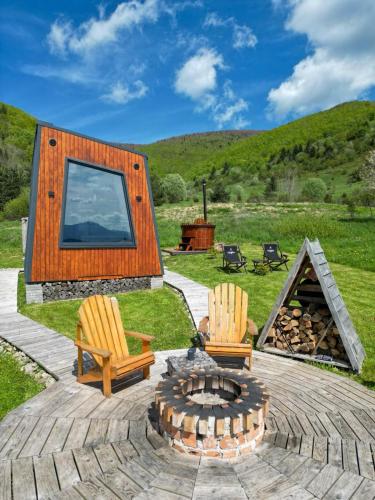 a backyard with two chairs and a fire pit at DANGUBA - Tiny Glamp House With Hot Tub by IGLENA in Kupres