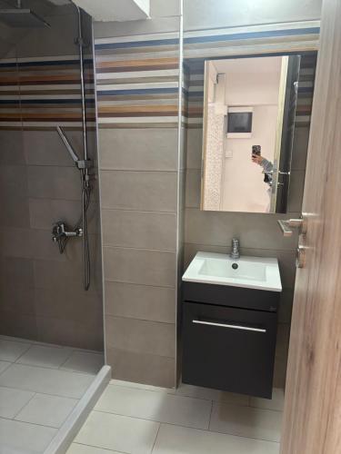 a bathroom with a sink and a mirror and a shower at Phoenix - Rise and Relax in Agia Galini
