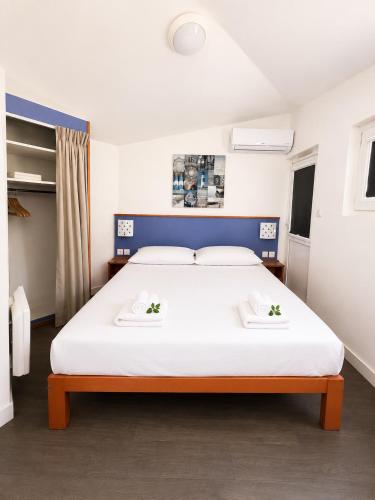 a bedroom with a large bed with white sheets at Charmant studio avec piscine 4 personnes in Fréjus