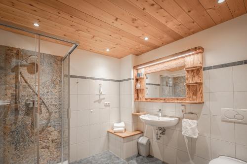 a bathroom with a shower toilet and a sink at Bergbauernhof Simmerl in Sachrang