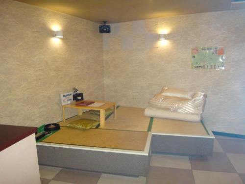 a room with a white chair and a table at Utility Hotel Coo in Yokoshibahikari