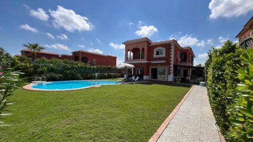 an exterior view of a house with a swimming pool at Caribiano villa-3 in Dawwār Ḩalīs