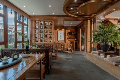 a dining room with a table and chairs and windows at Lijiang Cloud Return Huiyi · On the Water Side Panoramic Hidden Inn (South Gate Mufu Branch) in Lijiang