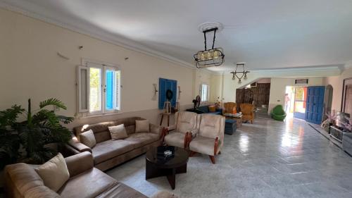 a large living room with couches and a living room with at Caribiano villa-3 in Dawwār Ḩalīs