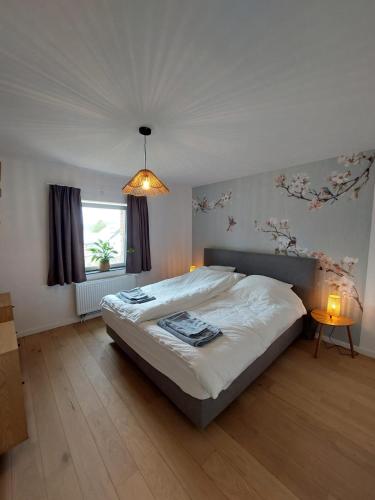 a bedroom with a large bed and a window at Ma maison de famille in Saint-Hubert