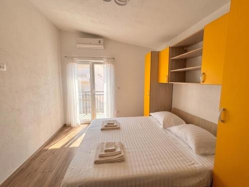 a bedroom with a large bed with towels on it at Apartments Šebin in Baška Voda