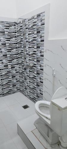 a white bathroom with a toilet and a shower at UrbanNOOK Basic in Rawalpindi