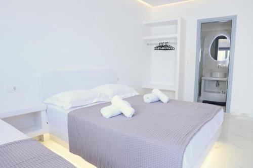 ein weißes Schlafzimmer mit zwei Betten und einem Waschbecken in der Unterkunft Tinamar Selections in Perivolos