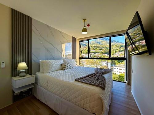 a bedroom with a bed and a large window at Panoramic view apartment with Pool and Rooftop in San Salvador