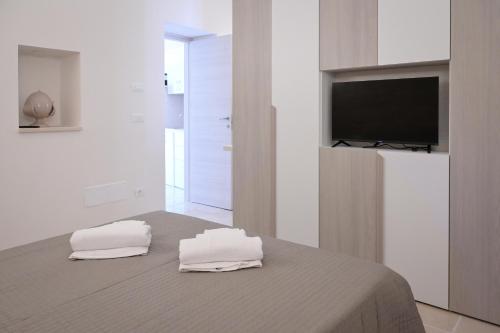 a bedroom with a bed with two towels on it at Dimora Donizzetti in Martina Franca