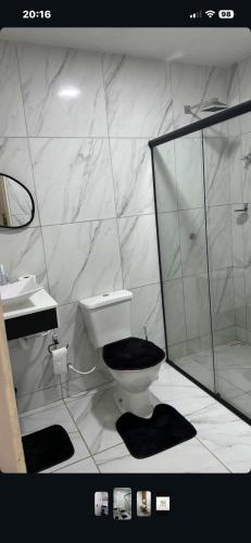 a white bathroom with a toilet and a shower at Casa Sol e mar in Tibau