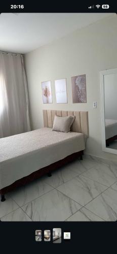 a bedroom with a bed with pictures on the wall at Casa Sol e mar in Tibau