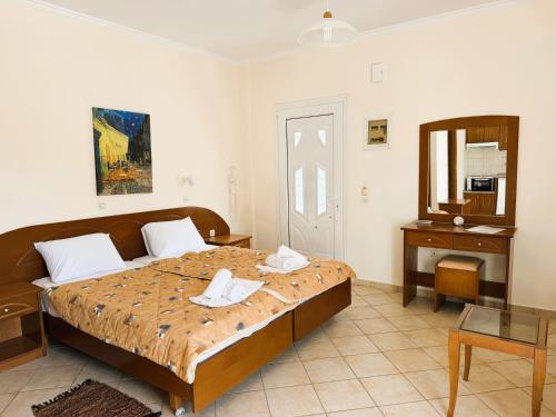 a bedroom with a bed and a table and a mirror at Celestine Apartment, Arillas, Korfu in Arillas