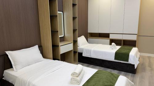 a hotel room with two beds with white sheets at Zafran Platinum Apartments in Dushanbe