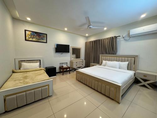 a hotel room with two beds and a tv at Bridge Residency in Islamabad