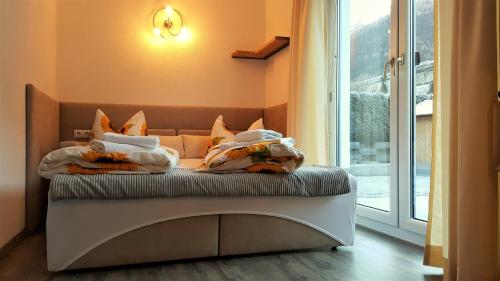 a bed with pillows on it next to a window at Ferienhaus Gundi in Pettneu am Arlberg