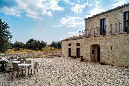 a patio with tables and chairs in front of a building at Tre Balate Natura e Relax in Modica