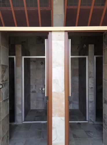 two glass doors in a room with a shower at Horizon Pines in Al Qbayyāt