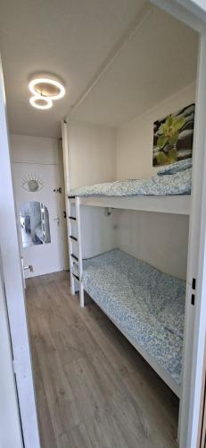 a small room with two bunk beds in it at Vertige Bleu, Vue mer, Port, Plage, WI-FI, Clim, Centre ville, Commerces, Calme in La Grande Motte