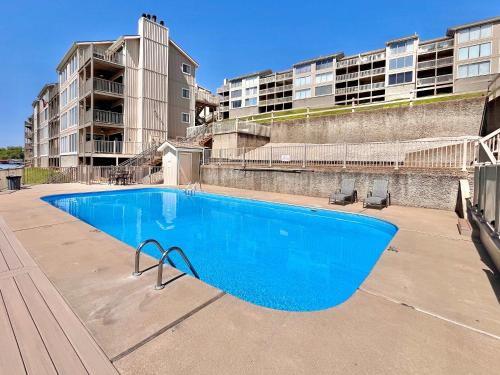 a large blue swimming pool in front of a building at Serenity Pointe Boat Slip in Osage Beach