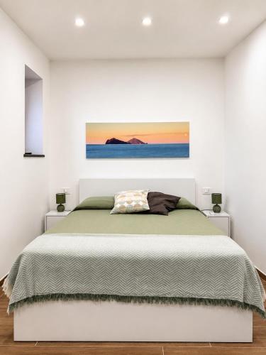 a bedroom with a bed and a painting on the wall at Holiday Home Tarinuzza in Lipari