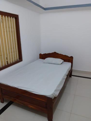 a small bed in a room with a window at CaReville Chunnakam in Chunnakam