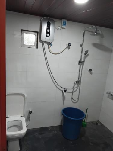 a bathroom with a shower and a toilet and a bucket at CaReville Chunnakam in Chunnakam