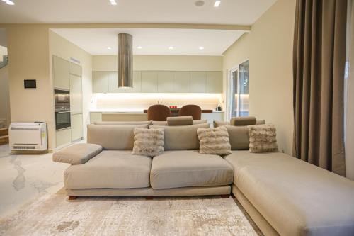 a living room with a large couch in front of a kitchen at Blue Coast-Vala Mar Villa in Hamallë