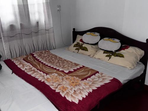 a bed with a blanket and pillows on it at The peace place in Ella