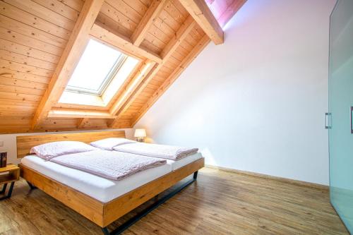 a bed in a room with a wooden ceiling at Ferienwohnung Bergele in Rot an der Rot