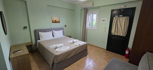 a bedroom with a bed with two towels on it at Bayside Apartments in Vasiliki