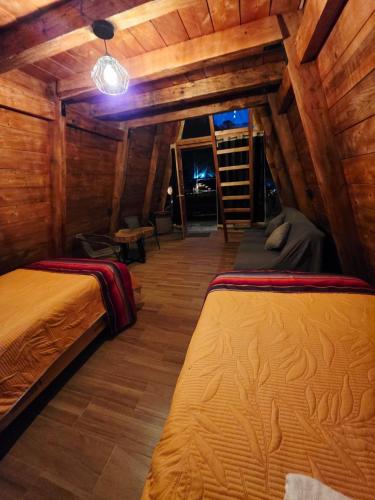 a bedroom with two beds in a wooden cabin at Chalet Cuarzo in Mineral del Chico