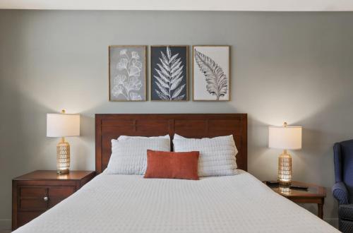 a bedroom with a white bed with three pictures on the wall at Big Spirit Resort in Spirit Lake