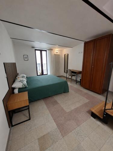 a bedroom with a green bed and a table at Dimora Tre Marie in LʼAquila