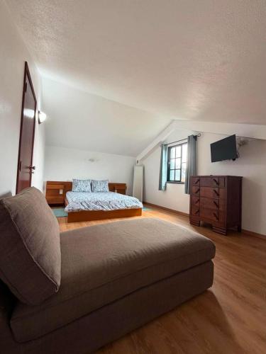 a bedroom with a bed and a couch at Quinta do Areeiro in Horta