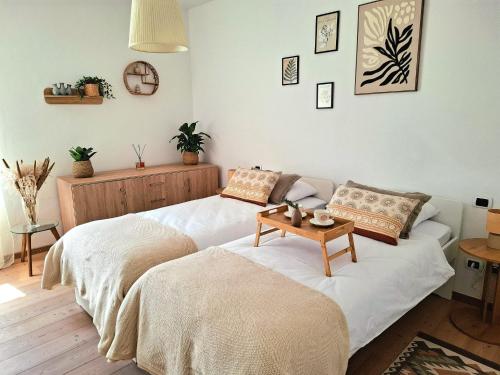 two beds in a living room with a table on it at Casa Ewa in Fiavè