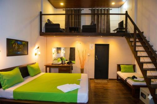a bedroom with a green bed and a staircase at Hotel Green Garden PVT LTD in Trincomalee