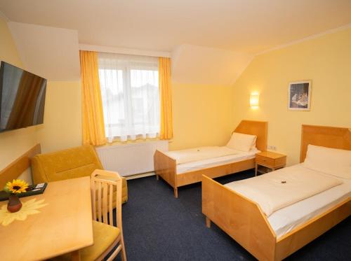 a hotel room with two beds and a table at Restaurant Gästehaus Seiger in Sankt Lorenzen bei Knittelfeld