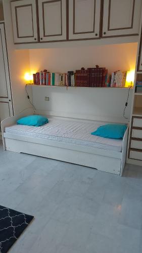 a white bed with blue pillows in a room at Cannes Park in Cannes
