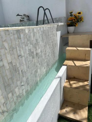 a swimming pool with stairs next to a wall at Mouradia Safara in Safara