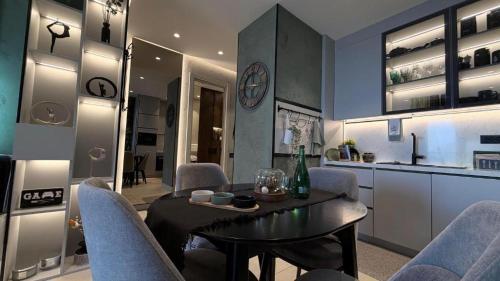 a kitchen and dining room with a table and chairs at KRUNA 406 Luxury Sea View Apartment with Parking, Minibar, Spa & Beach - Includes 2 Complimentary Non-Alcoholic Beach Drinks & Welcome Gift in Budva