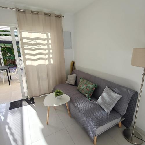 a living room with a couch and a table at Bungalow Gran Canaria Oasis in Maspalomas