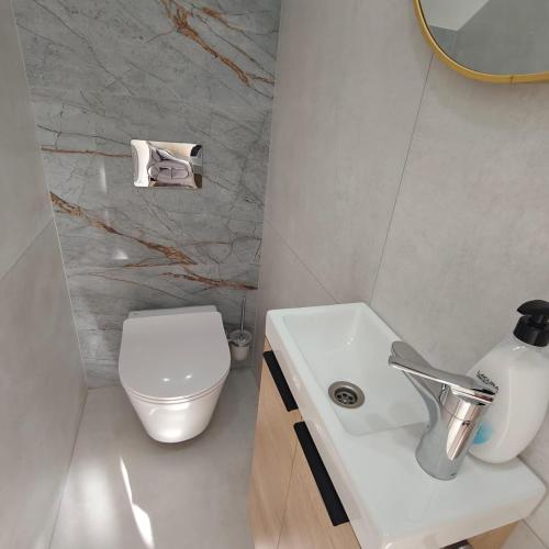 a bathroom with a white toilet and a sink at Bungalow Gran Canaria Oasis in Maspalomas