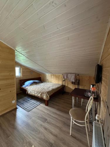 a bedroom with a bed and a table in a room at Гостинний двір Підкова in Budishche