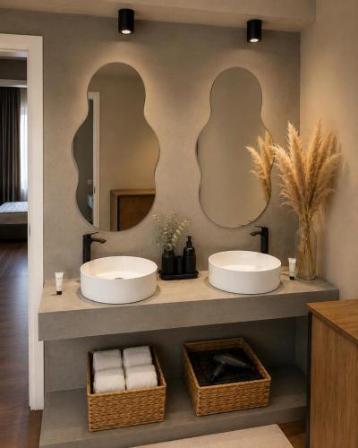 two sinks in a bathroom with two mirrors at Sea Hotel in Ksamil