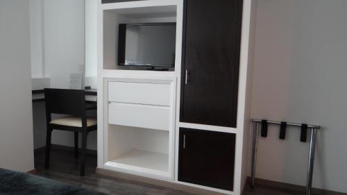 a white cabinet with a tv on top of it at Hotel Black Boutique in Mexico City