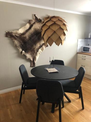 a dining room table with two chairs and a painting on the wall at Gårdens Stugor - stugor för självhushåll in Klimpfjäll