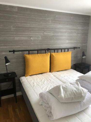 a bedroom with a bed with two yellow pillows at Gårdens Stugor - stugor för självhushåll in Klimpfjäll