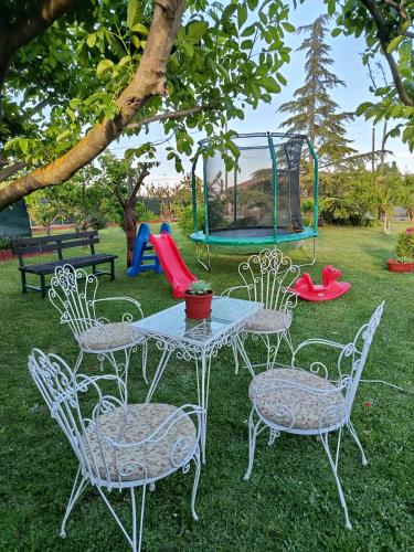 a table and chairs with a playground in the grass at Red Roses-Traditional House in Katerini