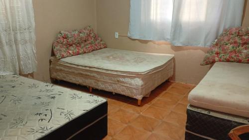 a small room with two beds and a couch at CasaZita in Passo De Torres
